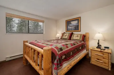 a bedroom with a wooden bed and a window at Beaver Village Unit #0621 in Winter Park