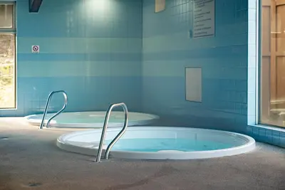 two hot tubs in a bathroom with blue tiles at Beaver Village Unit #0623 in Winter Park