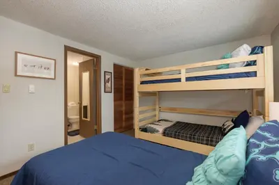 a bedroom with two bunk beds and a blue bed at Beaver Village Unit #0623 in Winter Park