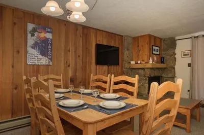 a dining room with a table and chairs and a television at Beaver Village Unit #0711R in Winter Park