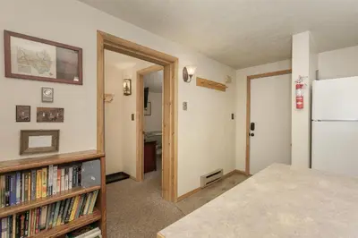 a room with a refrigerator and a book shelf with books at Beaver Village Unit #0711R in Winter Park