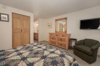 a bedroom with a bed and a chair and a television at Beaver Village Unit #0711R in Winter Park