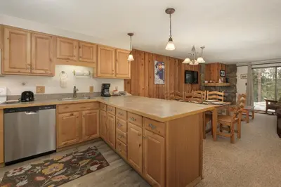a large kitchen with wooden cabinets and a dining room at Beaver Village Unit #0711 in Winter Park