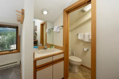 a bathroom with a toilet and a sink and a mirror at Crestview Place Unit 607 in Winter Park
