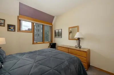 a bedroom with a bed and a dresser and a mirror at Crestview Place Unit 607 in Winter Park