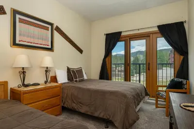 a bedroom with two beds and a balcony at Crestview Place Unit 607 in Winter Park
