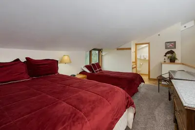 two beds in a hotel room with red sheets at Crestview Place Unit 607 in Winter Park