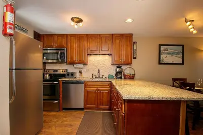 a kitchen with wooden cabinets and a stainless steel refrigerator at Beaver Village Unit #0211 in Winter Park