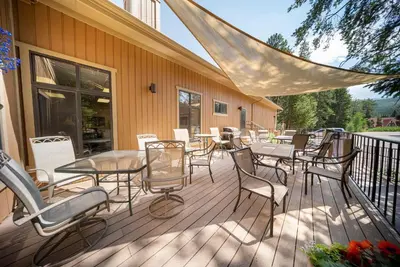 a deck with tables and chairs on a building at Beaver Village Unit #0332 in Winter Park