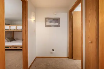 a hallway with a door leading to a bedroom with a bunk bed at Beaver Village Unit #0514 in Winter Park