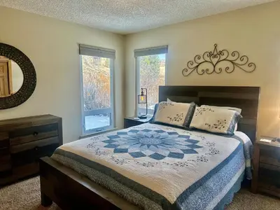 a bedroom with a bed and two windows at Hi Country Haus Unit 1801 in Winter Park
