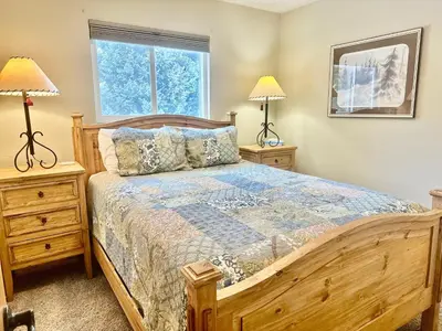 a bedroom with a wooden bed and two lamps at Hi Country Haus Unit 1801 in Winter Park