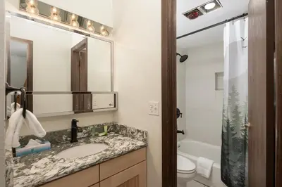 a bathroom with a sink and a toilet and a mirror at Hi Country Haus Unit 1908 in Winter Park
