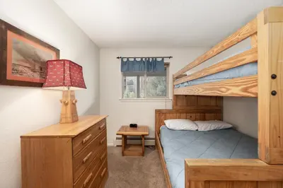 a bedroom with a bunk bed and a desk at Hi Country Haus Unit 1908 in Winter Park