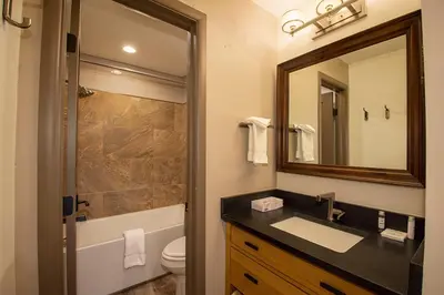 a bathroom with a sink and a toilet and a mirror at Hi Country Haus Unit 2121 in Winter Park