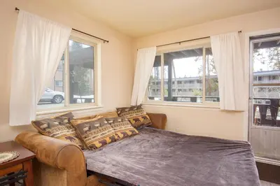 a bedroom with a couch and a bed with windows at Hi Country Haus Unit 0406 in Winter Park