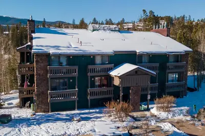 an apartment building with snow on the roof at Silverado I Building A Unit 101 in Winter Park