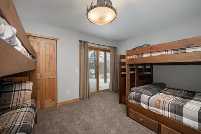 a bedroom with two bunk beds and a hallway at Silverado I Building A Unit 101 in Winter Park
