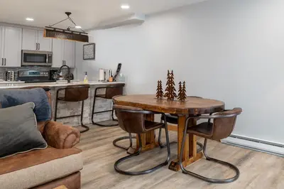 a living room with a table and a kitchen at Silverado I Building A Unit 101 in Winter Park