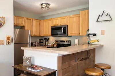 a kitchen with wooden cabinets and a stainless steel refrigerator at Waterside West A303 in Fraser