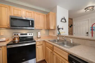 a kitchen with a sink and a stove and a microwave at Waterside West A303 in Fraser