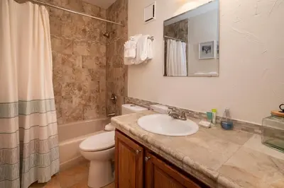 a bathroom with a sink and a toilet and a mirror at Creekside Unit 403 in Winter Park