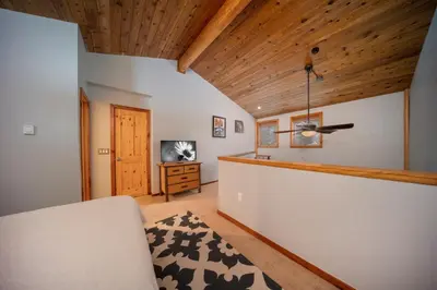 a room with a bed and a tv and a wooden ceiling at Creekside Unit 403 in Winter Park