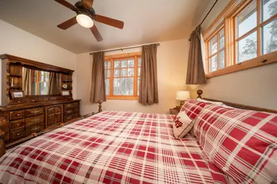 a bedroom with a large bed and a ceiling fan at 500 North Lupine in Fraser