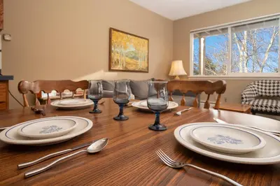 a dining room table with plates and silverware on it at Hi Country Haus Unit 0309 in Winter Park