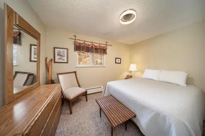 a bedroom with a bed and a chair and a window at Hi Country Haus Unit 0309 in Winter Park