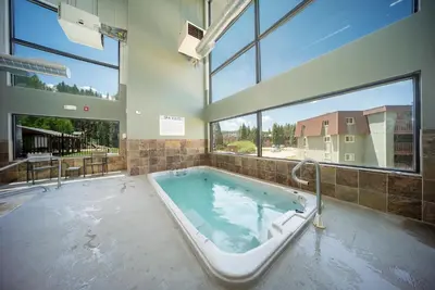 a large bath tub in a room with windows at Hi Country Haus Unit 1903 in Winter Park