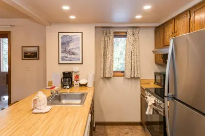 a kitchen with a sink and a refrigerator at Hi Country Haus Unit 2501 in Winter Park