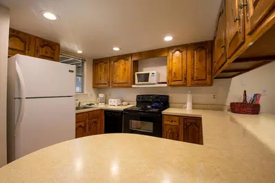 a kitchen with wooden cabinets and a white refrigerator at Hi Country Haus Unit 2111 in Winter Park
