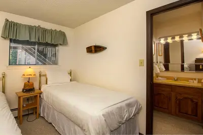 a bedroom with a bed and a sink and a mirror at Hi Country Haus Unit 2111 in Winter Park
