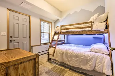 a bedroom with two bunk beds and a desk at Winter Park Townhome with Hot Tub, Ski Shuttle! in Winter Park