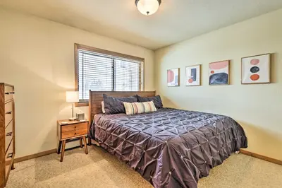 a bedroom with a bed and a table with a lamp at Winter Park Townhome with Hot Tub, Ski Shuttle! in Winter Park