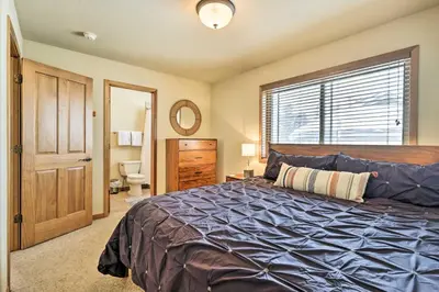 a bedroom with a large bed and a bathroom at Winter Park Townhome with Hot Tub, Ski Shuttle! in Winter Park