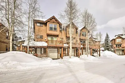 a large wooden house in the snow at Winter Park Townhome with Hot Tub, Ski Shuttle! in Winter Park