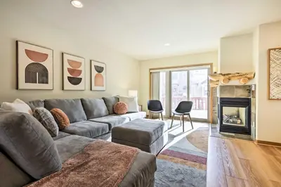 a living room with a couch and a fireplace at Winter Park Townhome with Hot Tub, Ski Shuttle! in Winter Park