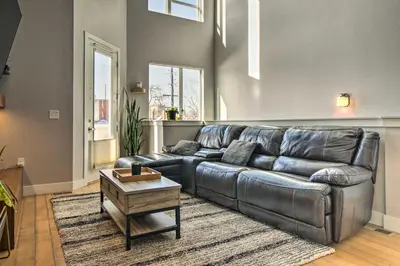 a living room with a leather couch and a table at Modern Townhome Rental 1 Mi to Downtown Denver! in Denver