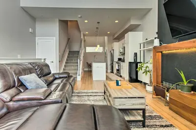 a living room with a leather couch and a tv at Modern Townhome Rental 1 Mi to Downtown Denver! in Denver