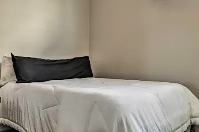 a bedroom with a white bed with a black pillow at Modern Townhome Rental 1 Mi to Downtown Denver! in Denver