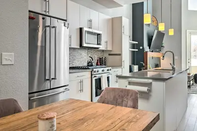 a kitchen with a wooden table and a refrigerator at Modern Townhome Rental 1 Mi to Downtown Denver! in Denver