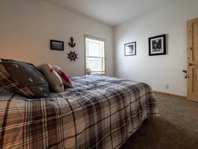 a bedroom with a bed with a blanket and a window at Stillwater, 0020 in Grand Lake