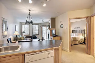 a kitchen with a sink and a bedroom with a bed at Silver Mill 8200 - 1Br-Walk to Slopes! Kids Ski Free! condo in Keystone