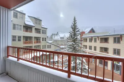 a balcony with a snow covered tree and buildings at Premier Silver Mill 8229 - 2Br-Walk to Slopes! Kids Ski Free! condo in Keystone