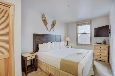 a bedroom with a large bed and a television at Premier Silver Mill 8229 - 2Br-Walk to Slopes! Kids Ski Free! condo in Keystone