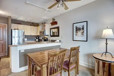 a kitchen and dining room with a wooden table and chairs at Silver Mill 8253 - 1Br-Walk to Slopes! Kids Ski Free! condo in Keystone