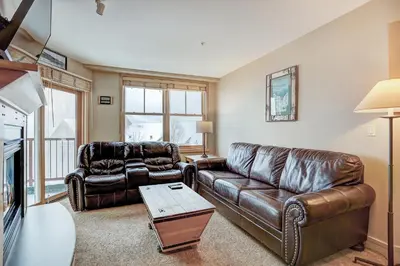 a living room with two leather couches and a tv at Silver Mill 8260 - 2Br-Walk to Slopes! Kids Ski Free! condo in Keystone
