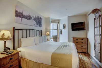 a bedroom with a large white bed and a dresser at Premier Silver Mill 8281 - 2Br-Walk to Slopes! Kids Ski Free! condo in Keystone